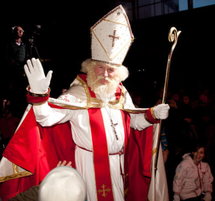 a man dressed as bishop nicholas waving to onlookers