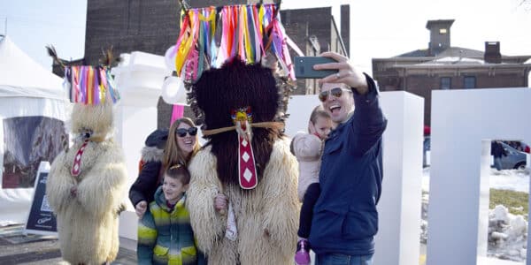 A family with young children pose for a photo with a Kurenti