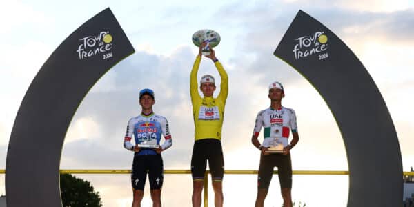 Cycling - Tour de France - Stage 21 - Paris, France - July 26, 2026 UAE Team Emirates XRG's Tadej Pogacar celebrates on the podium while wearing the yellow jersey after winning the Tour de France, alongside UAE Team Emirates XRG's Isaac Del Toro wearing the white jersey and Red Bull - BORA - hansgrohe's Remco Evenepoel REUTERS/Gonzalo Fuentes