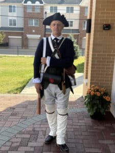 a man standing at attention in a revolutionary war uniform
